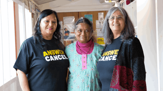 People wearing Answer Cancer t-shirts smiling at the camera